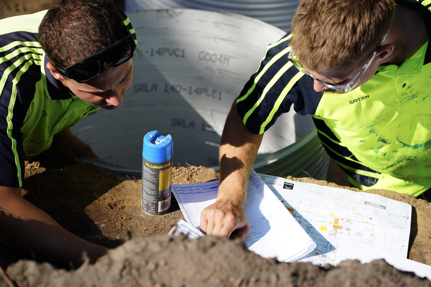 Two Hoad Drainage crew members reviewing plans together on site.