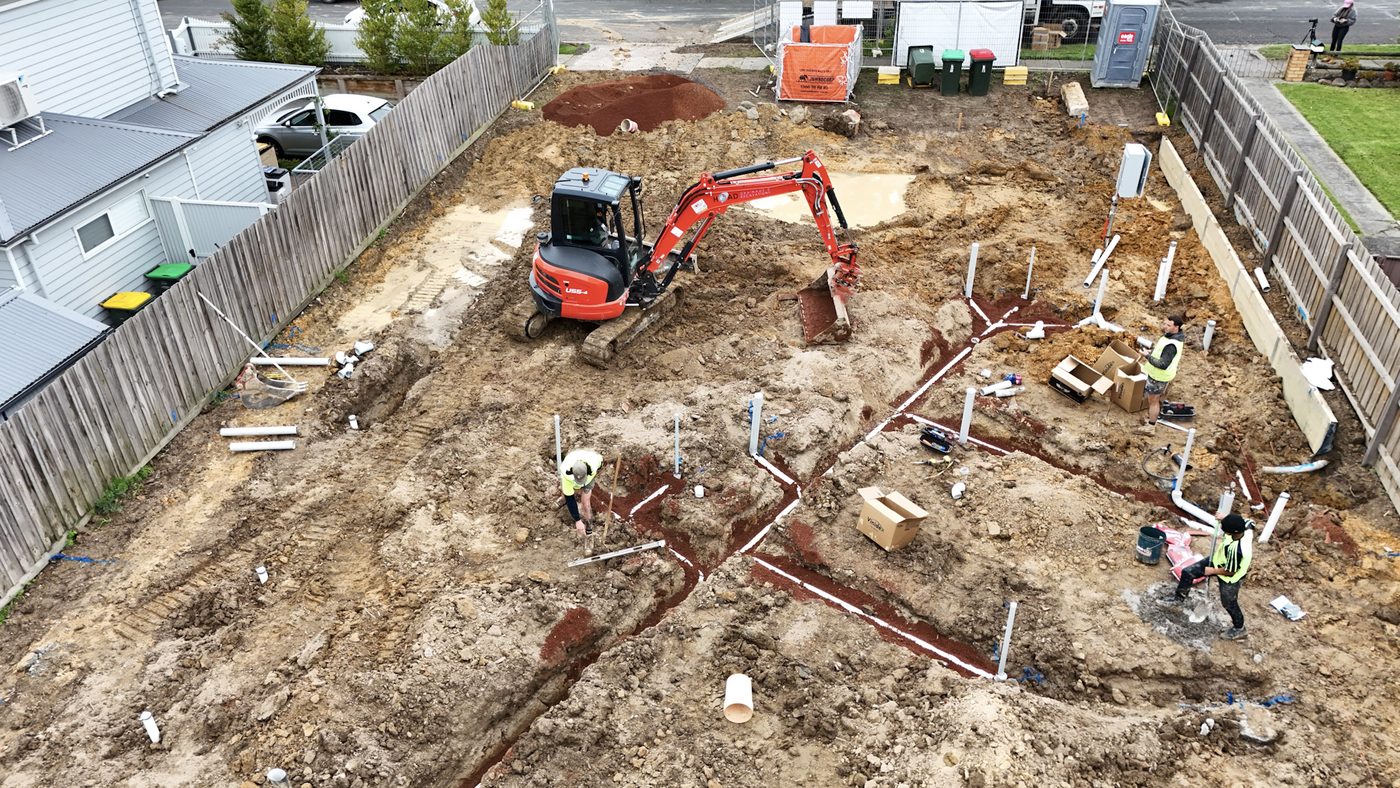 Open trench with drainage pipe laid on a residential site.