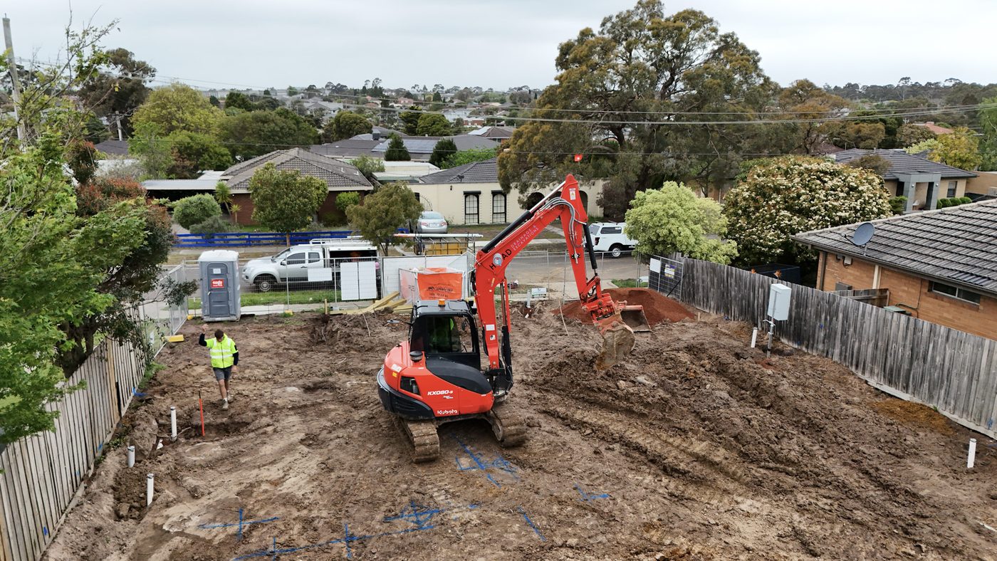 Compact Hoad Drainage excavator working on a residential site.